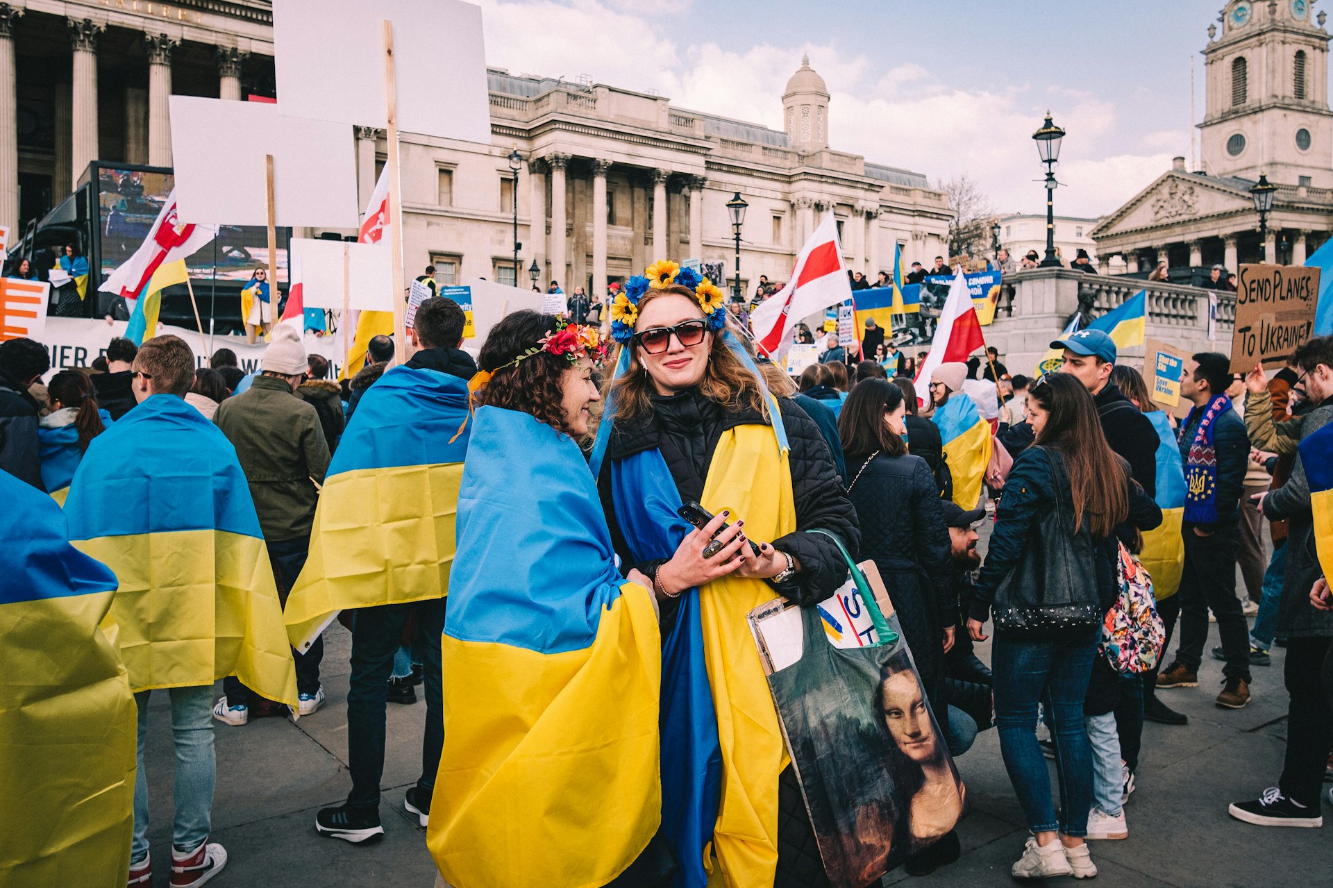 a group of people walking down a street holding flags